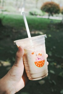手持卡通图案的美味奶茶