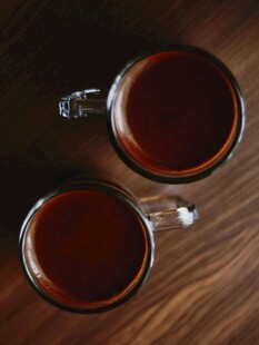 两杯热茶置于木质桌面上