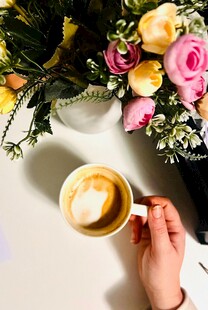 手捧咖啡与浪漫花束