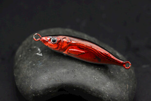 红色金属路亚饵置于石上
