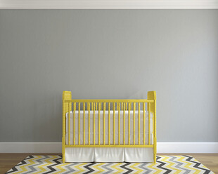 黄色婴儿床置于多彩地毯上