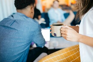 咖啡馆中手持咖啡的人物场景