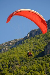 空中滑翔者翱翔青山之上