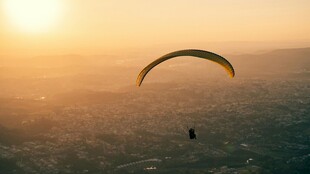 夕阳下的滑翔伞飞行