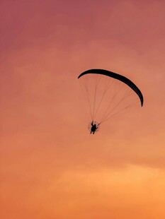 夕阳下的滑翔伞飞行