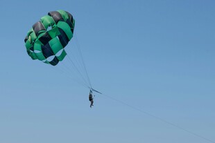 空中滑翔的绿色降落伞