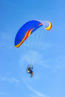 蓝天中单人动力滑翔伞飞行