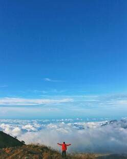 山顶之人拥抱云海蓝天