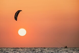 夕阳下的海上风筝冲浪