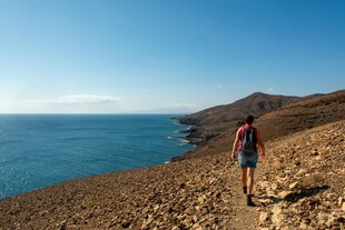 徒步者沿海边崎岖小径前行