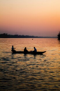 夕阳下三人泛舟湖面