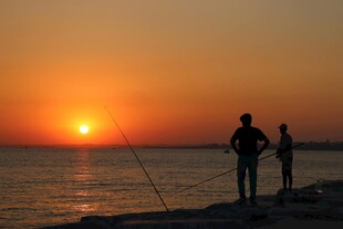 夕阳下的海边垂钓者