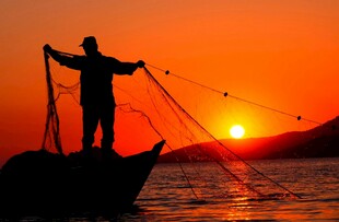 夕阳下渔夫撒网的剪影