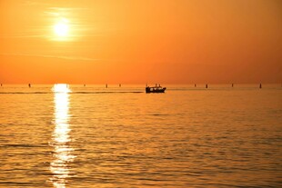 海上落日孤舟泛于波光间