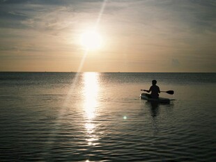 夕阳下的海上独舟垂钓者