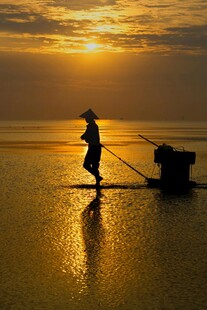 夕阳下的独舟渔夫