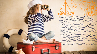 女孩坐箱前手持相机眺望