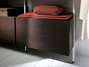 深色木质柜子上放着红枕