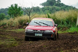 红色轿车驰骋于泥泞野外