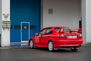 红色轿车停靠在建筑旁