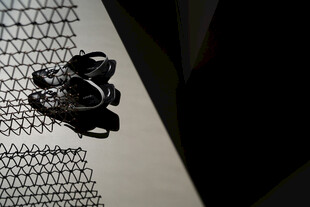 黑色鞋子置于金属网旁