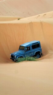 沙漠中行驶的蓝色越野车