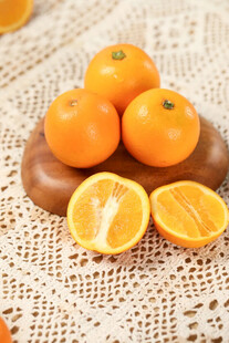 新鲜橘子摆放在蕾丝布上