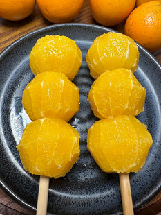 橘子糖葫芦摆放在深色盘上