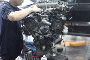 工人专注维修汽车发动机