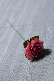 单枝粉玫瑰置于木质背景