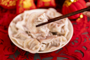 筷子夹起盘中美味饺子