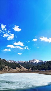 新疆喀纳斯蓝天雪山下的冰封湖泊