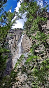 西藏拉萨布山间瀑布隐于葱郁绿树