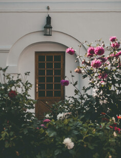 白墙花簇中的古朴窗户