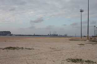 空旷沙滩与远处港口景象