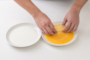 双手搅拌黄色食材画面