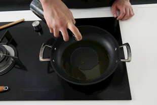 手在炉灶上操作煮锅