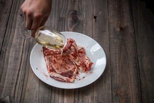 往肉片上倒油的烹饪场景