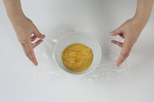 双手搅拌碗中黄色食材