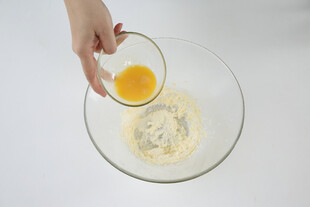手将蛋液倒入面粉碗中