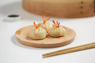 精致小笼包置于木盘上