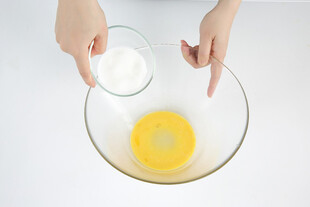 手添粉末入蛋液的烹饪场景
