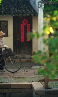 江南水乡骑车的蓑笠行人