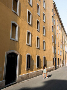 街道旁的黄墙建筑与行人