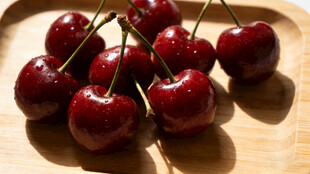 新鲜红樱桃摆放在木盘上