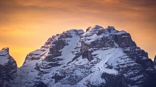 雪覆山峰映夕阳美景