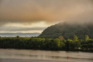 河畔晨雾中的葱郁山林