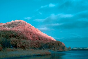 夕阳下的山丘与平静湖水
