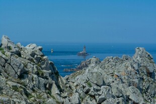 海边嶙峋岩石与远处灯塔