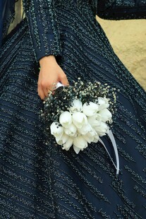 手持白花的深色服饰造型